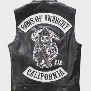 May include: Black leather vest featuring the Sons of Anarchy logo on the back. The vest has a large patch with the words "Sons of Anarchy" above a grim reaper graphic, and "California" below. The vest is sleeveless.