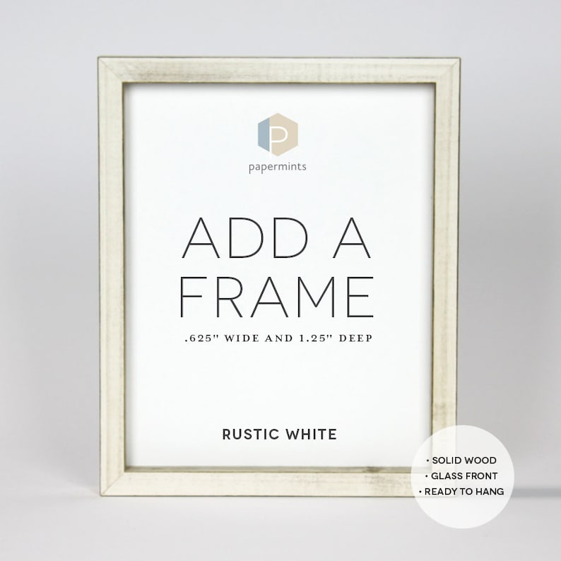 Op de afbeelding: Rustieke witte houten fotolijst met de tekst "ADD A FRAME .625" WIDE AND 1.25" DEEP" en "RUSTIC WHITE". De lijst is gemaakt van massief hout, heeft een glazen voorzijde en is klaar om opgehangen te worden.