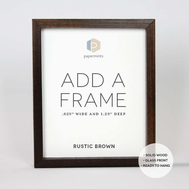 Op de afbeelding: Een rustieke bruine houten fotolijst met een witte passe-partout en de tekst "ADD A FRAME .625" WIDE AND 1.25" DEEP RUSTIC BROWN SOLID WOOD &bull; GLASS FRONT &bull; READY TO HANG" gedrukt op de passe-partout.
