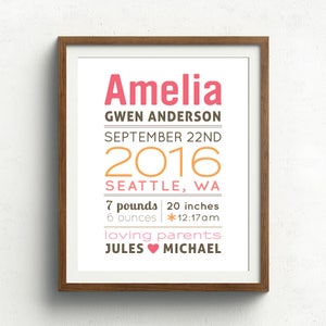 May include: A framed print with a white background and brown frame. The print features the name Amelia in pink, followed by Gwen Anderson, September 22nd, 2016, Seattle, WA, 7 pounds, 6 ounces, 20 inches, *12:17am, loving parents, Jules and Michael.