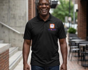 Polo deportivo para hombre con logo estampado en el pecho y la palabra EMPOWERED en la espalda.