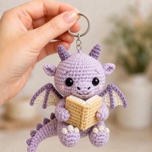 Llavero de ganchillo con forma de pequeño dragón lector, regalo para lectores de fantasía, dije amigurumi para amantes de los libros, lindo accesorio para bolso con forma de dragón lector.