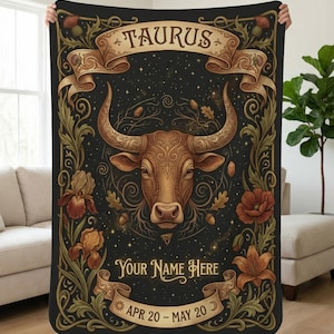 Könnte beinhalten: Eine schwarze Decke mit einer detaillierten Illustration eines Stierkopfes, dem Sternzeichen Stier. Das Design umfasst florale und Bandelemente mit dem Text "TAURUS", "Your Name Here" und "APR 20 - MAY 20".