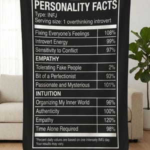 May include: Black blanket with white text that reads "PERSONALITY FACTS" and details about the INFJ personality type. The text includes percentages for traits like "Introvert Energy" and "Empathy."
