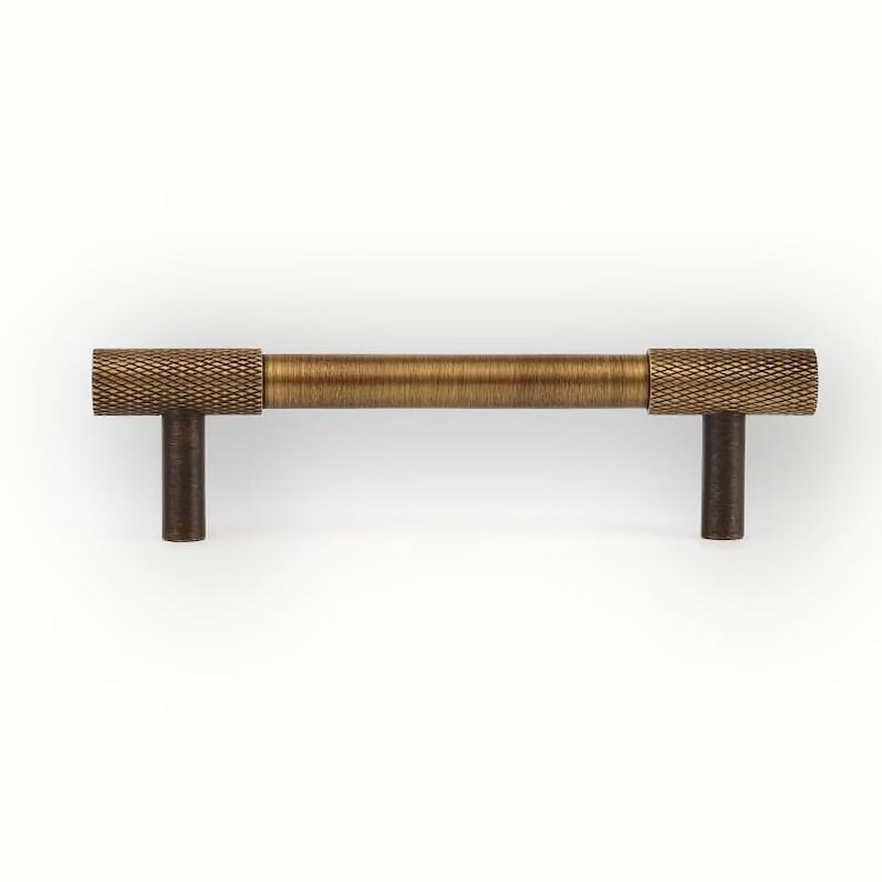Straight solid brass cabinet pull isolated on white background, minimalist drawer handle with knurled ends