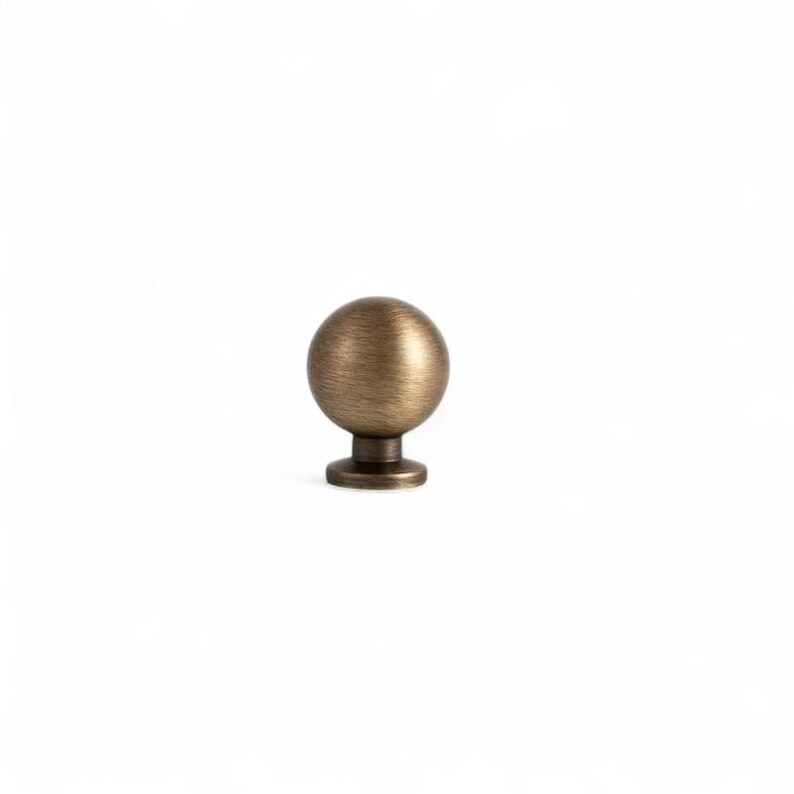 Side view of aged brass drawer knob, solid brass cabinet knob with rounded profile