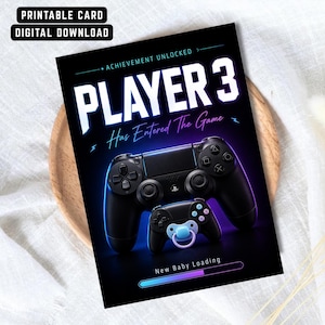 May include: A black card with the text "PLAYER 3 Has Entered The Game" and "New Baby Loading". The card features a large and small black game controller with blue and purple neon accents. The top of the card reads "PRINTABLE CARD DIGITAL DOWNLOAD".
