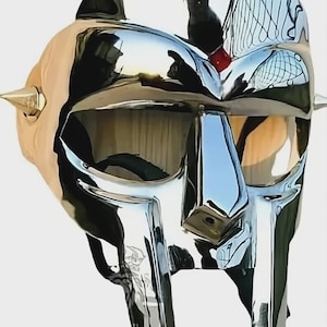 May include: A chrome-plated mask with a distinctive design, featuring a reflective surface and a stylized face. The mask has a metallic finish, with sharp angles and a unique shape, and is likely a decorative item or costume piece.