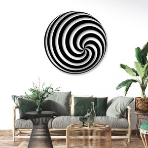 May include: A large, round wall art piece with a black and white spiral design. The artwork is mounted on a white wall above a sofa with green and gray cushions. The room is decorated with plants and wooden furniture.