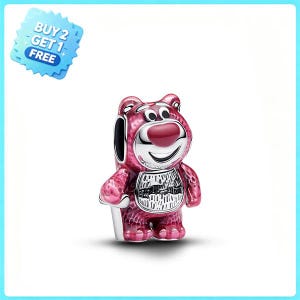 May include: A silver-toned metal charm shaped like a pink bear with a large red nose, wide eyes, and a smiling mouth. The bear has a textured belly panel and a smooth silver face. A blue star-shaped badge in the corner reads BUY 2 GET 1 FREE.