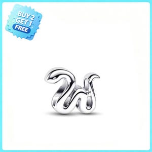Puede incluir: Un charm de metal plateado con forma de letra W y acabado liso y pulido. El diseño presenta líneas fluidas y curvas con un centro hueco. Una insignia azul en la esquina superior izquierda muestra el texto BUY 2 GET 1 FREE.