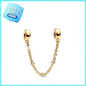 Könnte beinhalten: Eine goldfarbene Schmuck-Sicherheitskette mit zwei glatten, abgerundeten Endperlen, die durch eine feine Gliederkette verbunden sind. Die Kette ist mit drei kleinen, klaren, runden Steinen besetzt, die in Abständen entlang der Glieder sitzen.