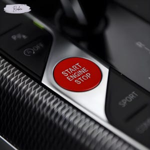 May include: Close-up of a car's dashboard with a red "START ENGINE STOP" button. The button is surrounded by a silver panel and black controls, including a "SPORT" button. The dashboard has a textured, patterned surface.