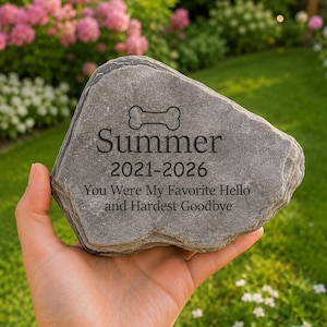 以下が含まれることがあります： 犬の骨のアイコン、名前Summer、2021-2026年、およびYou Were My Favorite Hello and Hardest Goodbyeというテキストが刻印された、自然な形の平らな灰色の記念石。表面と縁はざらざらとした質感です。