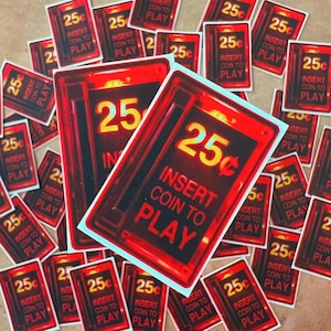 May include: A close-up of a stack of red and yellow stickers that say "25c Insert Coin to Play".