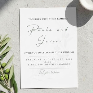Puede incluir: Una invitación de boda blanca con una elegante escritura que anuncia la boda de Paula y Javier. La invitación incluye la fecha, hora y lugar: sábado 23 de agosto de 2025, 18:00 H, Finca Los Olivos - Madrid. Rama de olivo y cuenco blanco.