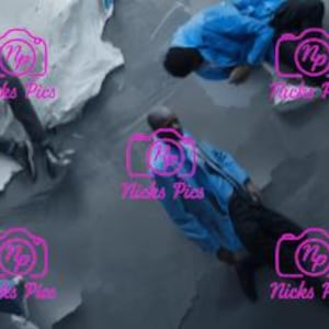 May include: Multiple figures in blue jackets and black pants are positioned on a textured, gray and blue surface. The figures are in various poses, some lying down, others in motion. The image has a modern, artistic aesthetic.