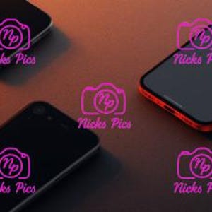 May include: An overhead shot of several smartphones in various colors, including black and bright orange. The phones are arranged on a dark surface, with a gradient of light across the top. The image has a modern, tech-focused aesthetic.