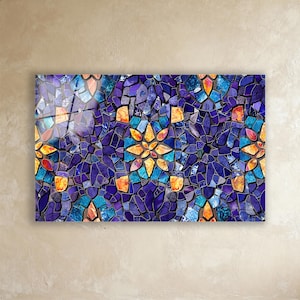 May include: A rectangular glass art piece with a mosaic design. The mosaic is made of irregular pieces in deep blue, purple, orange, and turquoise. The arrangement creates a floral pattern with a glossy finish, suitable for wall decor.