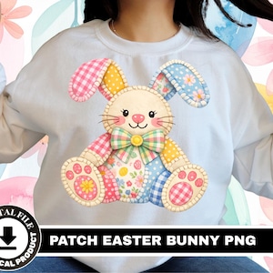 May include: White sweatshirt with a colourful patchwork Easter bunny design. The bunny has pink, yellow, and blue patterned ears, paws, and body sections. The design includes a bow tie and a smiling face. The text "PATCH EASTER BUNNY PNG" is at the bottom.