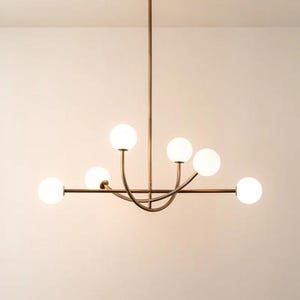 Pu&ograve; includere: Un lampadario moderno con finitura bronzo. L'apparecchio di illuminazione ha sei globi sferici in vetro smerigliato. L'apparecchio &egrave; sospeso al soffitto da un'unica asta.