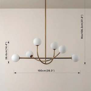 Pu&ograve; includere: Un lampadario moderno color oro con sei paralumi sferici in vetro bianco. L'apparecchio misura 100 cm di larghezza, 36,6 cm di altezza e ha un'altezza massima di 106,3 cm. Il supporto a soffitto ha un diametro di 10 cm.