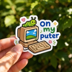 May include: A die-cut sticker featuring a light green caterpillar sitting on top of a beige vintage computer monitor. The screen displays a blue sky and green hills. Next to the computer is the blue and green text "on my puter" with a pink heart.
