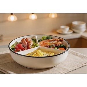 Puede incluir: Un cuenco blanco dividido con borde negro, lleno de gambas, brócoli, maíz y tomates. El cuenco está sobre un mantel individual beige, lo que sugiere una presentación de comida. El diseño del cuenco es sencillo y funcional.