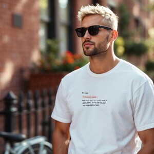 May include: A white t-shirt with the word "Error" and a message printed in black. The person in the image is wearing black sunglasses. The background includes a brick building and a bicycle.