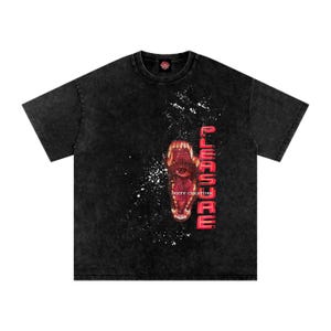 May include: Black t-shirt with a distressed wash. The front features a graphic of a creature's open mouth with an eye, the word "PLEASURE" in red, and the text "DIRTY CREATURE".