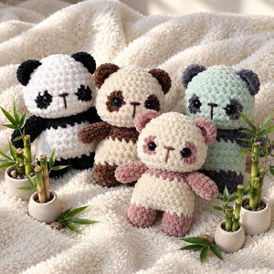 May include: Four crocheted panda plush toys in different color combinations including black and white, brown and cream, mint green and dark gray, and dusty pink and cream, each featuring round black eyes and small embroidered noses.
