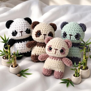 May include: Four crocheted panda plush toys in different colour combinations including black and white, brown and cream, mint green and dark grey, and dusty pink and cream, each featuring round black eyes and small potted bamboo plants nearby.
