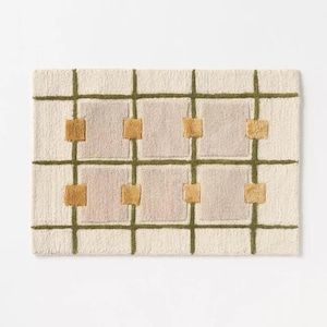 Puede incluir: Alfombra rectangular crema con un dise&ntilde;o de cuadr&iacute;cula. Las l&iacute;neas de la cuadr&iacute;cula son verde oliva y los cuadrados son de color rosa claro. Las intersecciones de la cuadr&iacute;cula tienen peque&ntilde;os acentos cuadrados de color amarillo dorado.