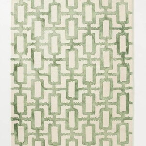 May include: Rectangular rug with a repeating geometric pattern in shades of green on a cream background. The design features interconnected rectangles, creating a modern look. Suitable for living rooms, bedrooms, or hallways. The rug measures approximately 150 cm x 200 cm.