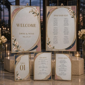 May include: A set of wedding signage featuring a welcome sign, a seating chart, a table number, a bar menu, and a dinner menu. Each piece has a textured light gray background, gold frames, and floral accents in pink, blue, and white.