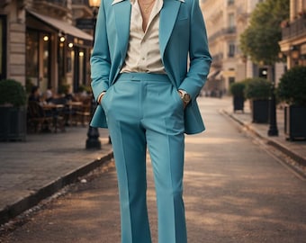 Può includere: Un abito azzurro con giacca con ampi revers e pantaloni a zampa abbinati. L'abito è indossato sopra una camicia fantasia con colletto ampio. La persona indossa occhiali da sole e un orologio d'oro. L'ambientazione è una strada europea.