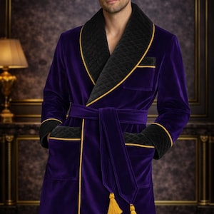 May include: A luxurious purple velvet robe with black quilted lapels and cuffs, trimmed with gold piping. The robe features a matching belt with gold tassels and pockets. The text "ELITE STITCH SUIT" is displayed at the top.