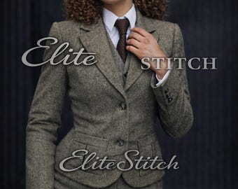 May include: A brown tweed suit featuring a blazer with two buttons, a matching vest, and trousers. The outfit includes a white collared shirt, a dark brown patterned tie, and a matching flat cap. The text Elite STITCH is visible on the image.