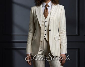 May include: A three-piece suit in cream with thin vertical pinstripes, featuring a blazer, a buttoned vest, and matching trousers. The suit is worn over a crisp white collared shirt and a textured brown tie. The text Elite STITCH appears twice.