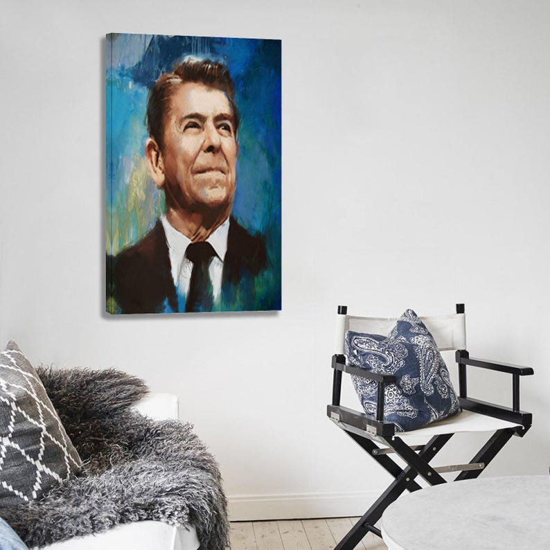 K&ouml;nnte beinhalten: Ein Gem&auml;lde eines Mannes in Anzug und Krawatte vor blau-gr&uuml;nem Hintergrund. Das Kunstwerk h&auml;ngt an einer wei&szlig;en Wand. Ein Regiestuhl und ein dekoratives Kissen befinden sich im Vordergrund.