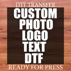May include: A DTF transfer design on a wood-grain background. The design features the words "CUSTOM PHOTO LOGO TEXT DTF" in bold white letters. The text "READY FOR PRESS" is at the bottom, and "DTF TRANSFER" is at the top.
