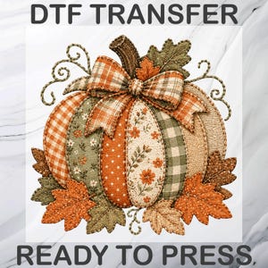 May include: A DTF TRANSFER READY TO PRESS graphic featuring a pumpkin composed of various fabric-like segments in orange, green, and cream colours with floral, polka dot, and plaid patterns, topped with a plaid bow and surrounded by autumn leaves.