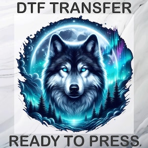 Peut inclure: Un transfert DTF prêt à presser présentant un graphique circulaire d'un loup aux yeux bleu vif. Le loup est centré devant une grande pleine lune, une silhouette de forêt sombre et des effets lumineux d'aurores boréales bleu et violet.
