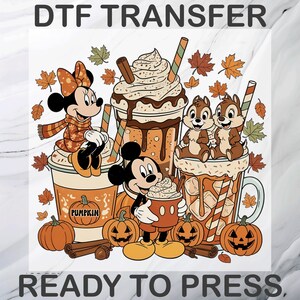 May include: A DTF transfer ready to press featuring a colorful illustration of cartoon characters with autumn-themed drinks, pumpkins, and falling leaves. The design includes text reading DTF TRANSFER and READY TO PRESS in bold black lettering.
