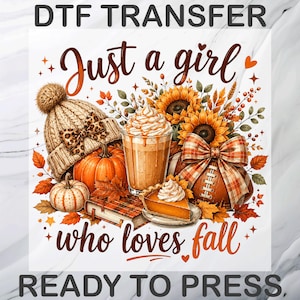 May include: A DTF transfer sheet featuring the text 'Just a girl who loves fall' and 'DTF TRANSFER READY TO PRESS'. The design includes a beige knit beanie with a leopard print bow, pumpkins, a coffee drink, sunflowers, a football, and a slice of pie.