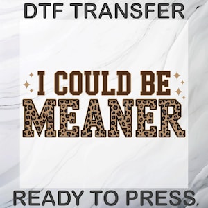 May include: DTF transfer with the text "I COULD BE MEANER" in brown and leopard print lettering. The words "DTF TRANSFER" and "READY TO PRESS" are at the top and bottom of the image, respectively. The background is a marble pattern.