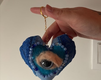 Amigo extraño: llavero de ojo malvado con corazón sagrado azul