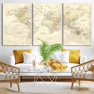 May include: A triptych of vintage world maps, each panel displaying a detailed cartographic representation. The maps feature a sepia-toned color palette with country names and geographical details. The artwork is displayed above a white sofa with yellow pillows.
