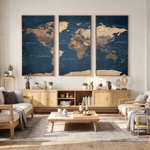 May include: Three framed world maps with a vintage aesthetic. The maps feature a dark blue background with tan-colored continents and are displayed above a wooden cabinet. The maps are a decorative element for a living room.