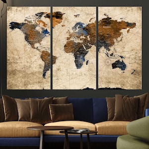 May include: A three-panel world map art print with a vintage aesthetic. The map features brown, blue, and tan tones, with country names and grid lines. The artwork is displayed above a blue and tan sofa with brown throw pillows.